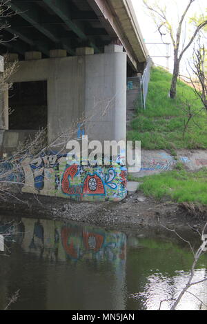 Graffiti unter der Brücke entlang des Flusses gefunden. Stockfoto