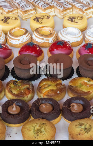 Eine Anzeige der Bunten cup cakes und Süßwaren, die auf einem Tisch in Borough Market in London. Kuchen und Backen an einem Konditoren abgewürgt. Stockfoto