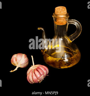 Zwei Knoblauch und öl Server auf schwarzem Hintergrund Stockfoto