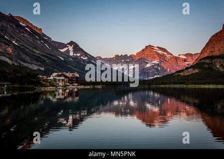 Swiftcurrent Lake und Reflexionen von Grinnel Point und Mount Henkel bei Sonnenaufgang im Glacier National Park, Montana, USA. Stockfoto