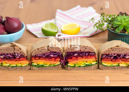 Rainbow salat Sandwiches mit hausgemachtem Brot, Buchweizen auf einem Holzbrett angezeigt. Diese frische, gesunde Mittagessen ist kalorienarm, Molkerei kostenlos & Glutenfrei. Stockfoto
