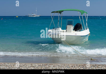 Angelegtes Boot auf den Strand von Kolymbia und der Fuß Yacht im Mittelmeer (Rhodos, Griechenland). Stockfoto