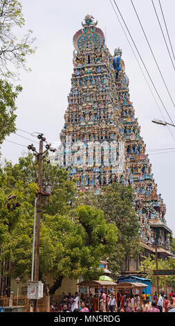 Madurai, Indien - März 10, 2018: Pilger unter einem der Tower Gateway, bekannt als Gopurams, an der Meenakshi Tempel Komplex Stockfoto