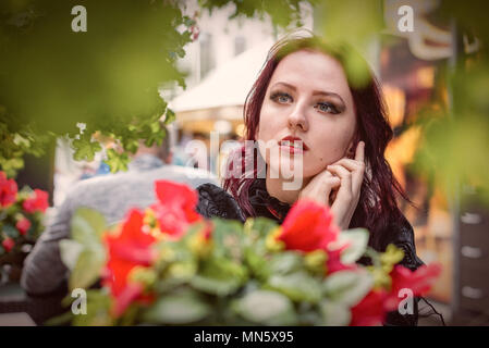 Junge wunderschöne rothaarige Frau sitzt in einem Cafe in Retro Mode gekleidet. Stockfoto