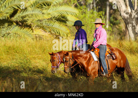 Mutter und Tochter reiten Pferde auf einem Bauernhof. Stockfoto