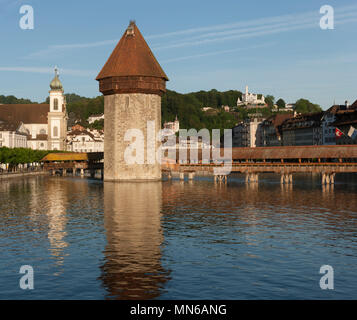 Historische Wahrzeichen Covered Bridge und Tower über dem Vierwaldstättersee in der Schweiz im Bereich des Tourismus, Reflexionen in See, Gutsch hotel, blauer Himmel Hintergrund Stockfoto