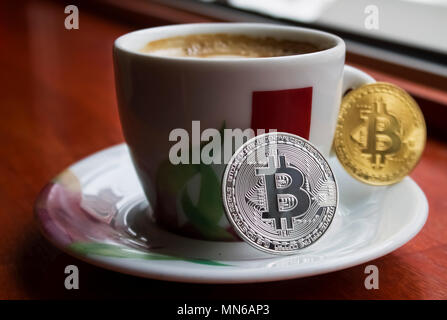 Zwei bitcoins eine silberne zweites Gold auf dem Porzellan Tasse Kaffee | Zukunft | Zahlung | Trinken Stockfoto