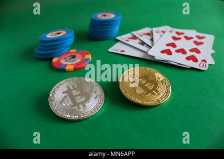 Zwei bitcoins zur Festlegung auf grün Pokertisch und Haufen von Chips mit Karten im Hintergrund | Gold | Silber | blau | Spülen Stockfoto