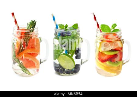 Drei Arten von Frucht-Enttox-Wasser in Maurergläsern mit auf weißem Grund isolierten Strohhalmen Stockfoto