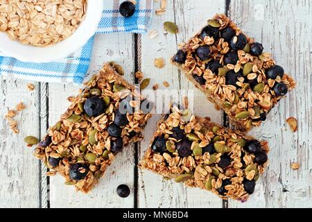 Superfoods Frühstück bars mit Hafer und Heidelbeeren, Overhead auf weißem Holz Hintergrund Stockfoto