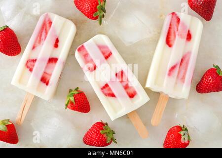 Gesunde Erdbeer Joghurt Eis am Stiel, Ansicht von oben auf einem Marmor Hintergrund Stockfoto