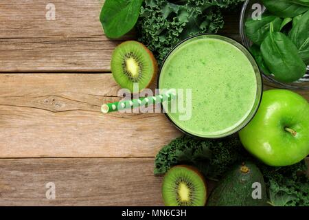 Grüne Smoothie oben Ansicht mit Grünkohl, Avocado, Spinat, Apple und Kiwi gegen einen rustikalen Holzmöbeln Hintergrund Stockfoto