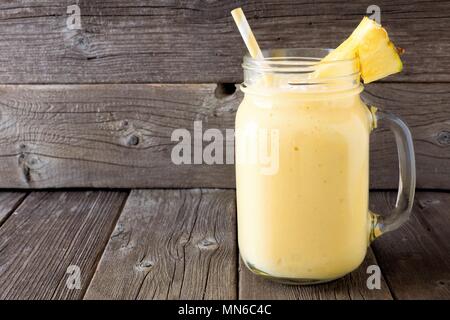 Ananas Smoothie in einem Marmeladenglas, gegen einen rustikalen Holzmöbeln Hintergrund Stockfoto