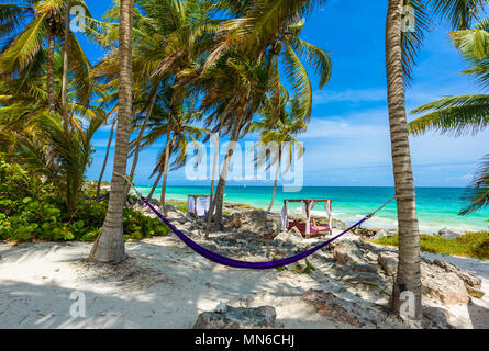 Strand Betten und Hängematte unter Palmen am Paradise Beach im Tropical Resort. Riviera Maya - karibische Küste in Tulum, Quintana Roo, Mexiko Stockfoto