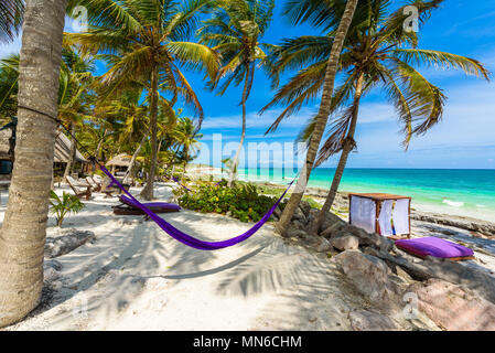 Strand Betten und Hängematte unter Palmen am Paradise Beach im Tropical Resort. Riviera Maya - karibische Küste in Tulum, Quintana Roo, Mexiko Stockfoto