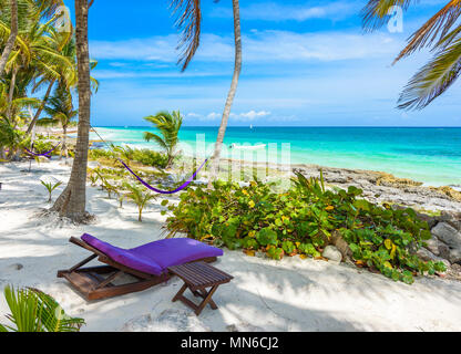 Strand Betten und Hängematte unter Palmen am Paradise Beach im Tropical Resort. Riviera Maya - karibische Küste in Tulum, Quintana Roo, Mexiko Stockfoto