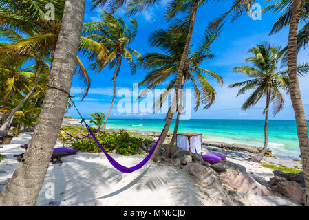 Strand Betten und Hängematte unter Palmen am Paradise Beach im Tropical Resort. Riviera Maya - karibische Küste in Tulum, Quintana Roo, Mexiko Stockfoto