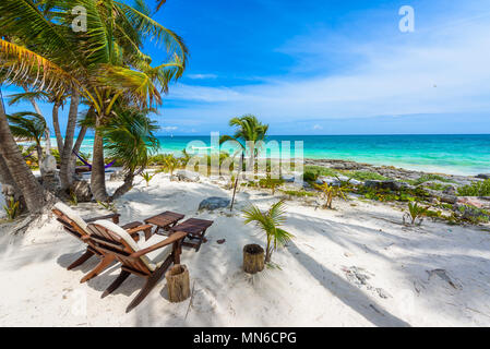 Stühle unter den Palmen am Paradise Beach im Tropical Resort. Riviera Maya - karibische Küste in Tulum, Quintana Roo, Mexiko Stockfoto