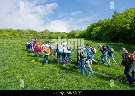 Wien, Österreich - April 2018: Schulklasse einen Ausflug in einer Wiese der Wienerwald. Kinder genießen Sie die Natur an einem sonnigen Frühlingstag. Stockfoto