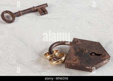 Hochzeit Ringe durch ein rostiges Lock gebunden Stockfoto