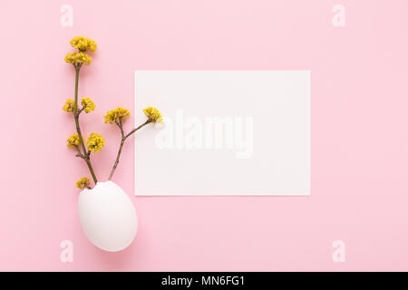 Mockup mit weißen Karte und blühende Zweige in Eierschale auf rosa Hintergrund. Frühling und Ostern Grußkarten-Konzept. Ansicht von oben. Stockfoto