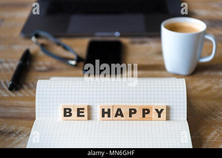 Nahaufnahme auf das Notebook um Holz Tisch Hintergrund, auf Holzblöcken mit Buchstaben machen glücklich Worte konzentrieren. Business Concept Bild. Stockfoto