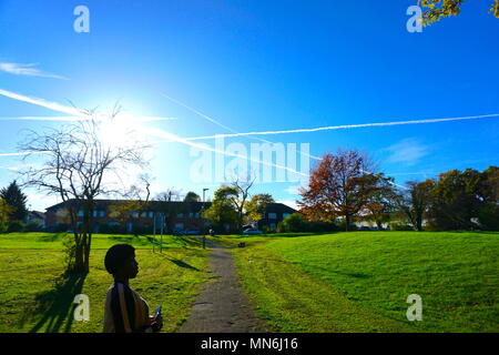 Jet-Auspuff, Chemtrail-Muster über der Silkstream PK in Edgware, London, England, U.K Stockfoto