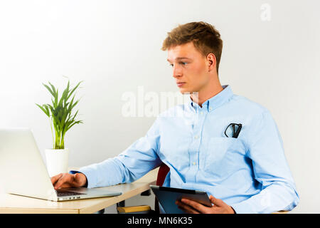 Schwerpunkt junger Mann, als er auf seinem Laptop zu erhalten alle seine Geschäfte gemacht Stockfoto