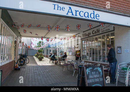 Die Arcade aus der Hohen Straße in der Ortschaft Goring-on-Thames in Oxfordshire, UK, mit Menschen außerhalb von Tabellen in einem Cafe sitzen Stockfoto