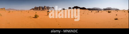 Panorama mit Allradantrieb, Foot Print und Kamele in der Wüste Wadi Rum mit Sandstein Formationen Hintergrund Stockfoto