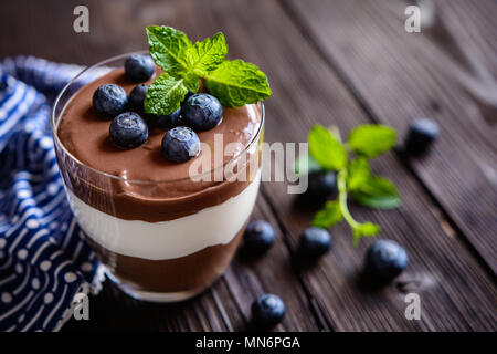 2-in-1-Schokolade und Vanille mascarpone Nachtisch gekrönt mit Blaubeere, im Glas serviert. Stockfoto