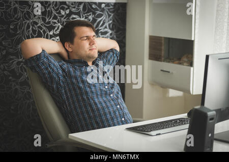 Getönten Porträt der jungen hipster Mann entspannen in großen Ledersessel mit Home Office Stockfoto