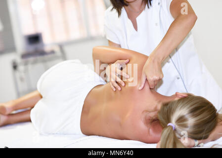 Professionelle female Physiotherapeutin, Massagen, blonde Frau im Krankenhaus. Medizinische Check an der Schulter in der Physiotherapie. Stockfoto
