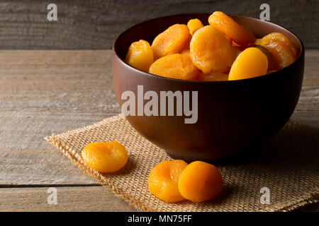 Ganze getrocknete Aprikosen Obst in Houten auf hölzernen Tisch Hintergrund Stockfoto