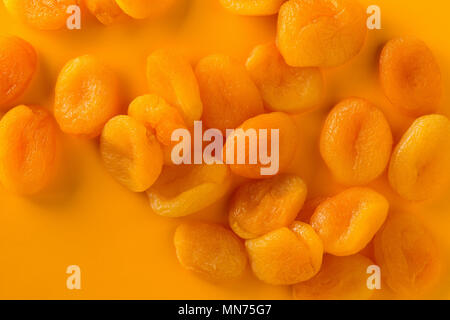 Haufen von getrockneten Aprikosen Obst über orange Hintergrund Stockfoto