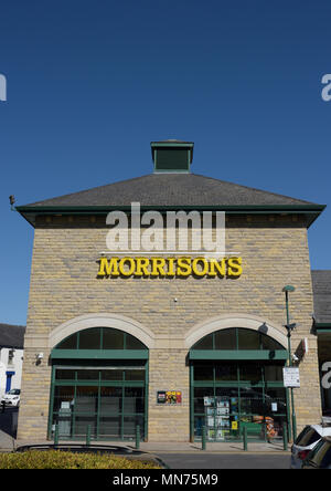 Morrisons Supermarkt mit Steinmauer zwei Steinfensterbögen und Schieferdach mit klarem blauen Himmel in ramsbottom lancashire uk Stockfoto