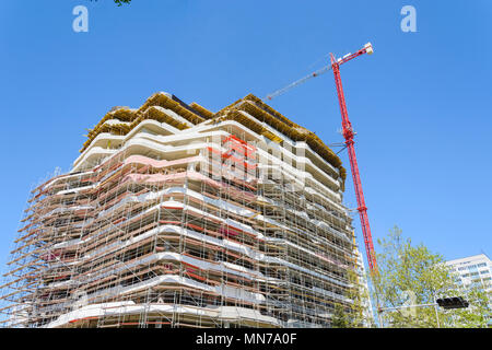 Hohes Gebäude in Bau mit Gerüst am blauen Himmel Stockfoto