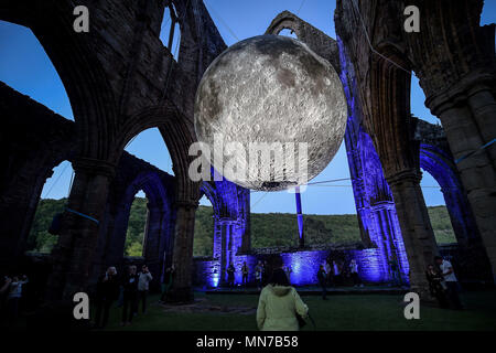 Besucher bewundern Künstler Luke Jerram der Installation Museum der Mond in Tintern Abbey in Newport, Wales. Die kunstwerke, vorgestellt als Teil des Wye Valley River Festival, handelt es sich um eine Replik des Mondes, sieben Meter Durchmesser, in der Klosterruine hängen durch Musik begleitet. Stockfoto