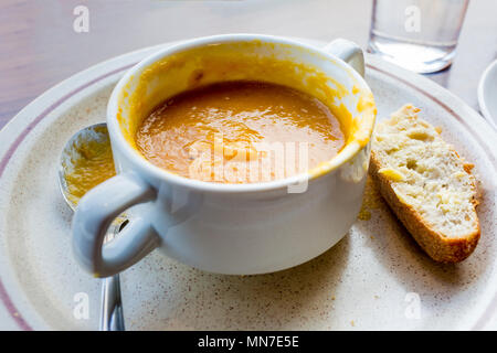 Die Hälfte gegessen Schüssel von Gemüsesuppe mit Brot und Löffel auf Cafe Zähler Stockfoto