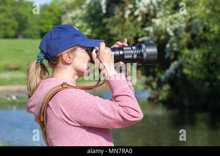 Northampton, Großbritannien Wetter. Eine junge Dame die Fotos der Vögel in den See diese hellen, sonnigen und warmen Morgen in Abington Park mit der Prognose für das gleiche Alle zu bleiben. Credit: Keith J Smith./Alamy leben Nachrichten Stockfoto