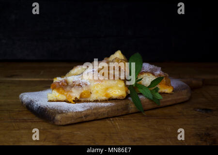 Aprikosen Kuchen mit Minze auf einem rustikalen Holzbrett Stockfoto