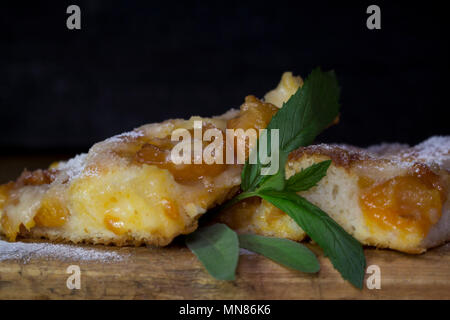 Aprikosen Kuchen mit Minze auf einem rustikalen Holzbrett Stockfoto