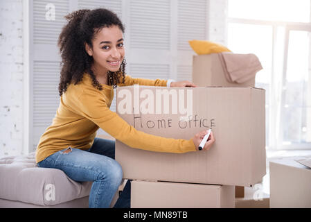 Upbeat Mädchen Unterzeichnung Box mit Sachen für das Home Office Stockfoto