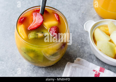 Tropischen Cocktail Sangria mit Weißwein, Ananassaft, Erdbeeren, Kiwi, Mango und Apple. Bio Trinken. Stockfoto