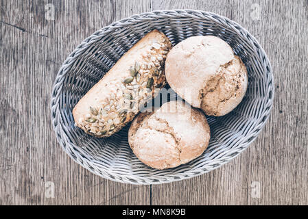 Ansicht von oben in den Warenkorb mit deutschen Stil Brötchen auf rustikalen Holztisch Stockfoto