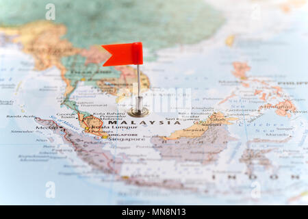 Kleine rote Fahne markiert das afrikanische Land von Malaysia auf einer Weltkarte. Stockfoto