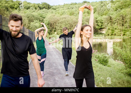 Eine Gruppe von Freunden, die sich nach dem morgendlichen Lauf im Park Stockfoto
