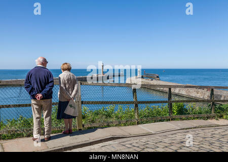 Ein älteres Paar Blick auf Meer in Whitby, North Yorkshire, England, Großbritannien Stockfoto