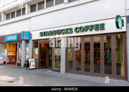 Benachbarten Branchen Greggs und Starbucks Kaffee auf einem Britischen High Street. Stockfoto