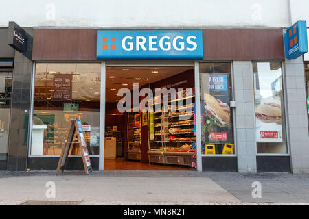 Ein Zweig der Greggs an einem Wochentag morgens im Vereinigten Königreich/Greggs Storefront, Greggs High Street, Greggs Logo. Stockfoto